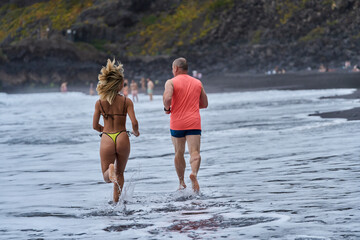 Couple jogging on volcanic beach