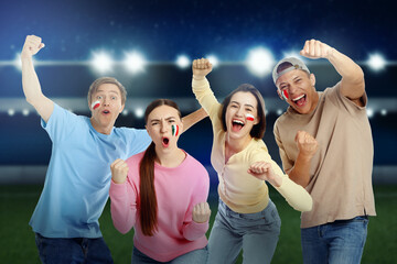 Excited football fans with flags painted on their faces at st
adium