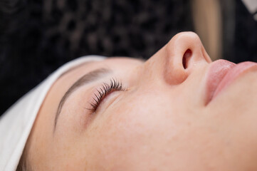 The process of professional eyelash lamination in a salon. 