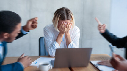 Victimization At Workplace. Colleagues Shouting At Unhappy Victimized Businesswoman, While She...