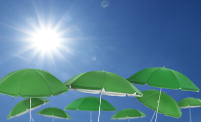 Green beach umbrellas against blue sky on sunny day