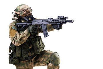 Tactical soldier in camouflage aiming rifle isolated on white background