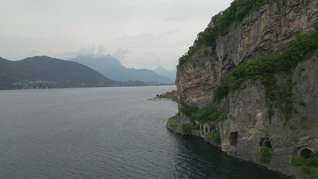 Mountain road tunnels along Lake Como between Olcio and Lierna, Italy, with lush cliffs and scenic alpine backdrop on a summer day
