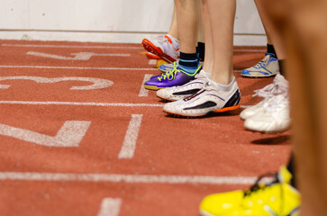 Illustrative image of athletic competition: runner’s spikes lined up at the start of a...