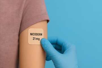 high-resolution image of a 21 mg nicotine patch being applied to upper arm by gloved hand, ideal for medical, pharmaceutical, and smoking cessation themes