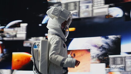 Curious astronaut standing on a distant planet in space suit and helmet, collecting samples beneath...