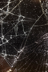 broken with a lot of pieces of glass on a black background, thin glass broken into pieces, closeup