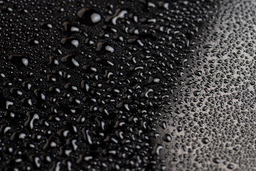 black wet surface covered with a large number of water droplets black surface, closeup