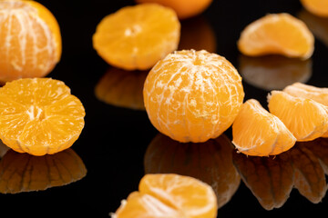 the reflection of a white orange citrus tangerine in a black mirror surface, a beautiful peeled and...