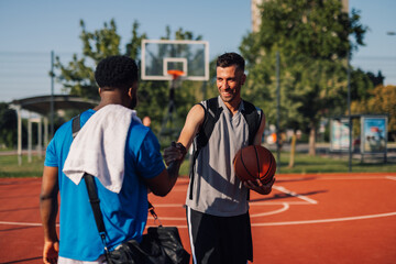 Two basketball players shaking hands after game on outdoor court