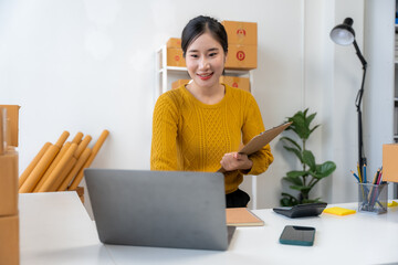 Asian Woman Managing Online Business at Home