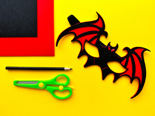 DIY Halloween mask. Handmade bat mask made of felt on a yellow background for Halloween. Felt...