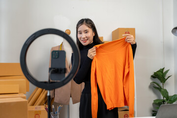 Woman Presenting Orange Sweater for Online Sale