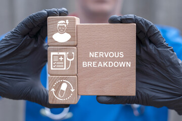 Doctor holding wooden blocks with icons sees the inscription: NERVOUS BREAKDOWN. Nervous breakdown meadical therapy concept. Treatment of stress and overwork.