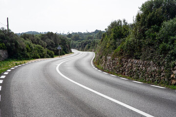 Winding road through green hills and forest landscape, serpentine
