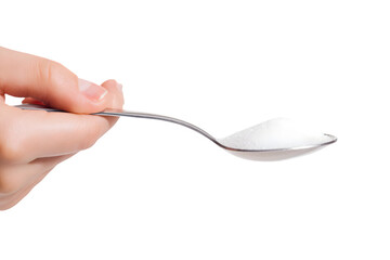 A hand holding a spoon of white granulated sugar against a black background a perfect ingredient shot for food blogs and culinary websites