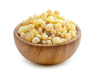 Close-up of a rustic wooden bowl overflowing with golden translucent crystalline pieces on a bright white background, highlighting detailed wood grain and rough textured amber
