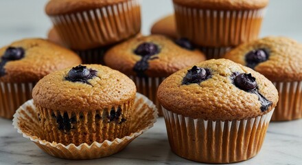 Freshly Baked Blueberry Muffins with Golden Brown Tops and Juicy Blueberries on a Marble Surface