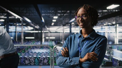 Happy technician next to server hub engineering team colleagues reviews AI diagnostics. Cheerful...