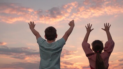 Friends together outdoors. Concept of success, kids victory. Children teamwork, group of children playing in park. Boy and girl raise their hands. Successful team of children winners. Family teamwork