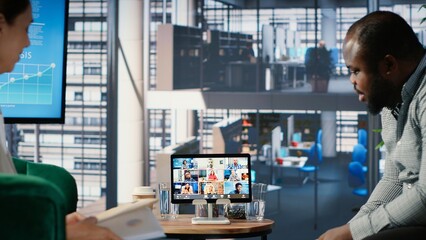 Multiethnic group of business leaders meeting with investors on video call online, working together...