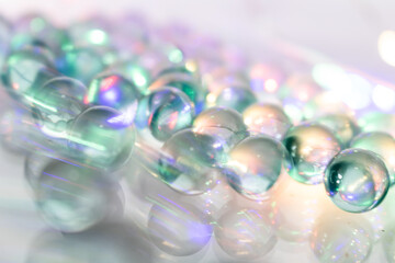 Moving colorful Iridescent Spheres on Reflective Surface with Light Reflections and Translucent...