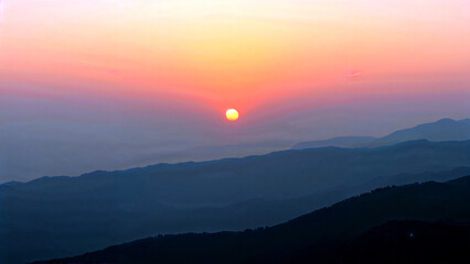 Obraz premium Majestic sunrise over hazy mountain peaks