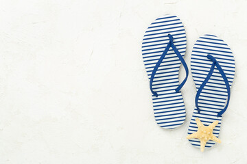 Striped blue flip flops on concrete background, top view