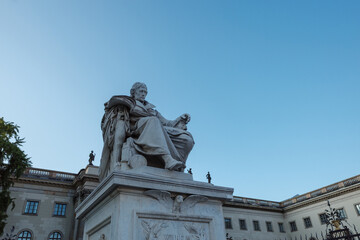 Obraz premium The monument to Wilhelm von Humboldt, the Prussian philosopher and founder of the university, stands proudly in front of the main building of Humboldt University in Berlin 
