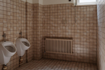 Interior of a vintage public restroom with urinals in Berlin.