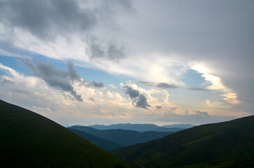 Serene view of a mountainous landscape featuring gentle hill slopes, dense forestry, soft daylight,...