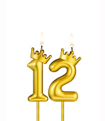 Golden number 12 birthday candle on white background