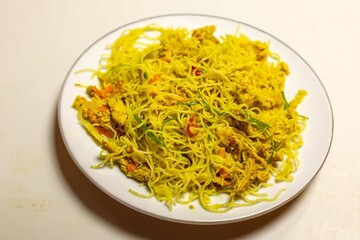 Traditional Asian food rice noodles known as bifum, with chicken, vegetables and curry