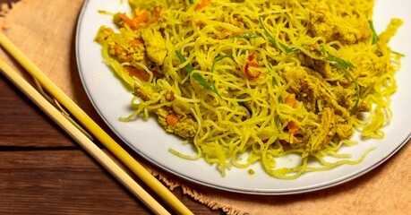 Traditional Asian food rice noodles known as bifum, with chicken, vegetables and curry