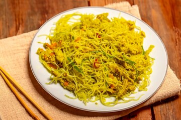 Traditional Asian food rice noodles known as bifum, with chicken, vegetables and curry