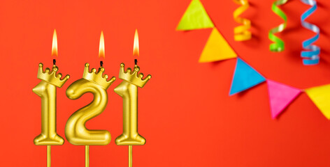 Number 121 candle - Birthday celebration on an orange background with pennants