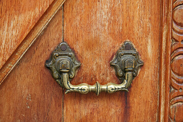 Manija antigua de metal sobre puerta de madera