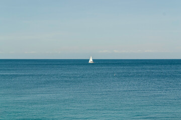 Fototapeta premium Minimalist Seascape with Lone Sailboat on the Horizon. Background, copy space
