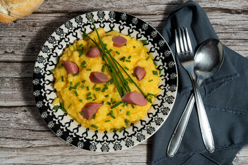 Creamy polenta with sliced sausage and chopped chives: delicious comfort food