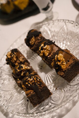 Sweet snacks in the gala. Closeup view of dark chocolate brownies with nuts, in a fancy dish
