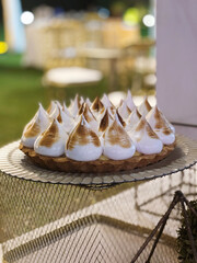 Traditional celebration cake. Closeup view of a Lemon pie with delicious meringue, in a social event with a beautiful gala setting