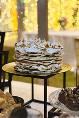 Traditional argentinian dessert. Closeup view of a Rogel cake with crispy layers, dulce de leche and meringue, in a social event with a beautiful gala setting