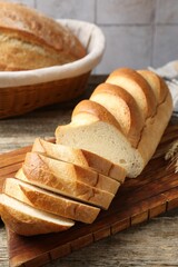 Cut bread loaf on wooden table, closeup