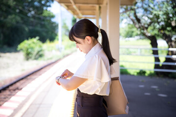 駅のホームで電車を待つ女性
A woman waiting for a train on the station platform
