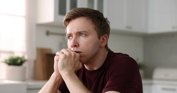 Paranoia. Worried man looking around in kitchen