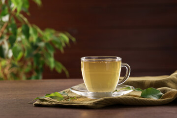Cup of tasty green tea on wooden table