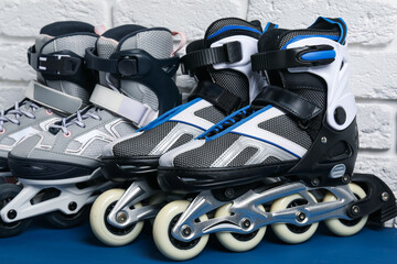 Roller skates on blue table near white brick wall, closeup