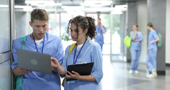 Medical students in uniforms with laptop indoors