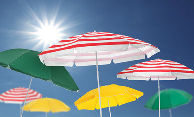 Different bright beach umbrellas against blue sky on sunny day