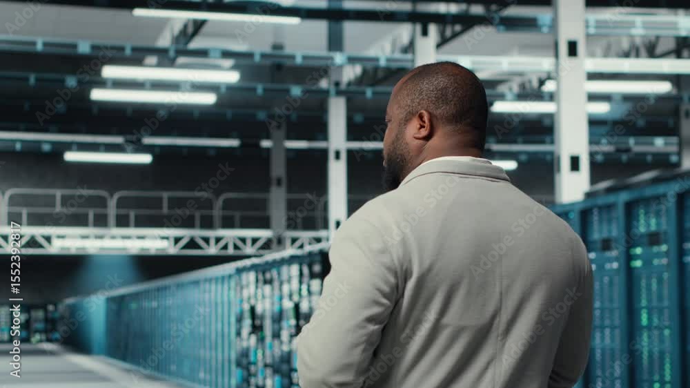 Poster system administrator walking in data center with rows of fully operational rackmounts. it expert ove